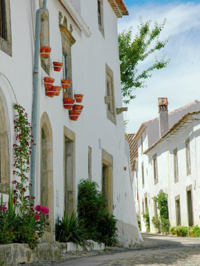 Afbeelding van woningen met een witte betonnen structuur, met groene en rode planten