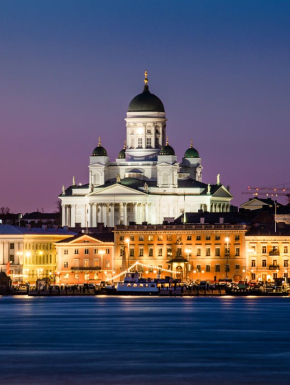 Foto van een kathedraal vlakbij gebouwen en en rivier in Helsinki, Finland.